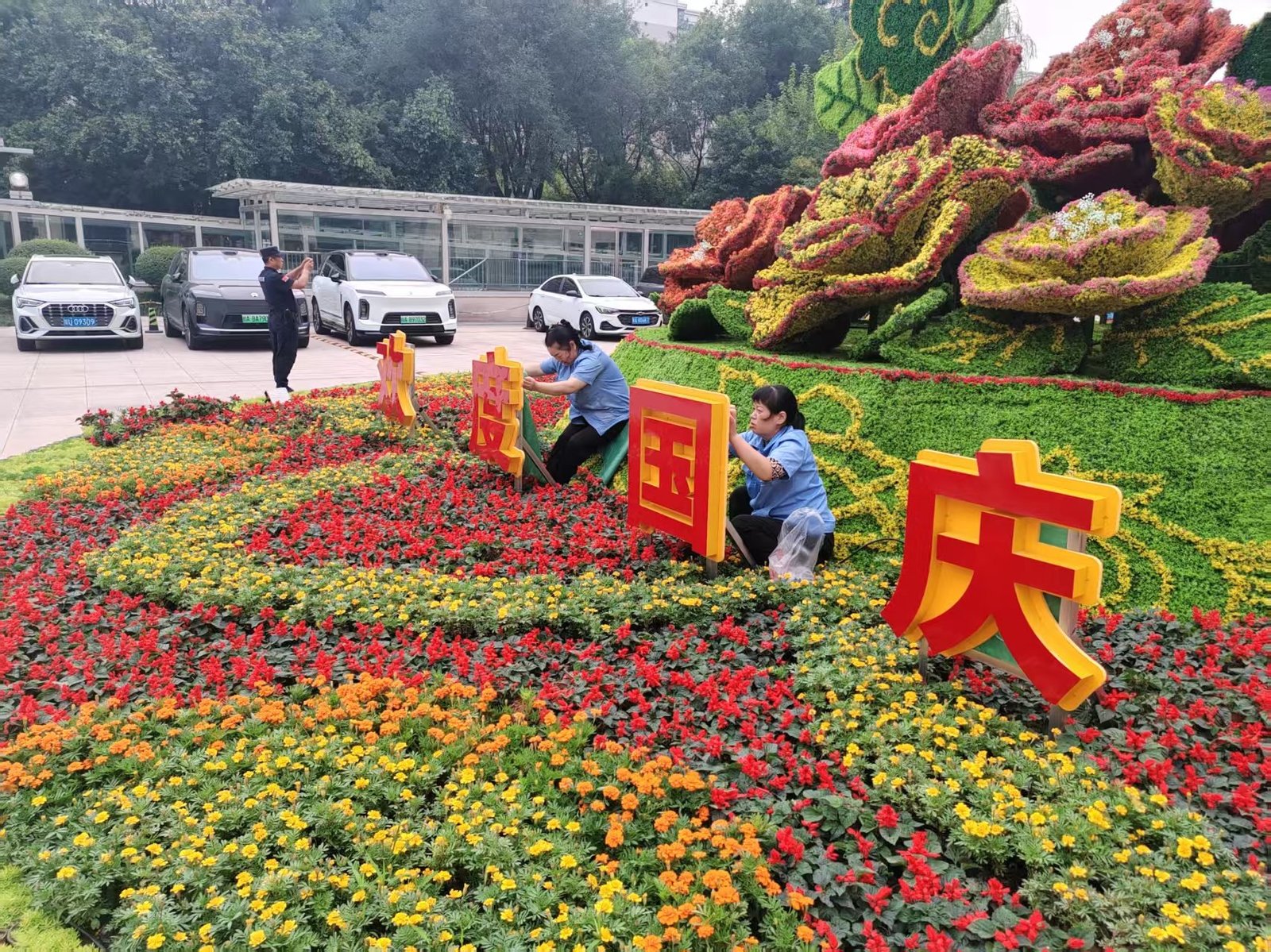 科海园林施工人员在企业广场安装国庆主题花坛标识
